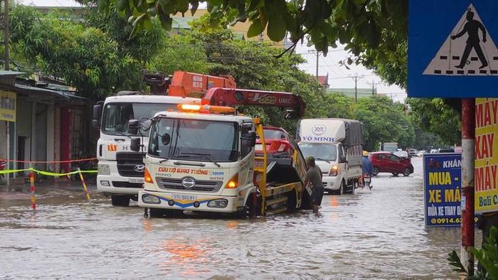 Lực lượng cứu hộ hỗ trợ đưa ô tô ra khỏi đoạn đường ngập tại phường Thành Vinh, Nghệ An, chiều 20/8. (Ảnh: Song Hoàng)