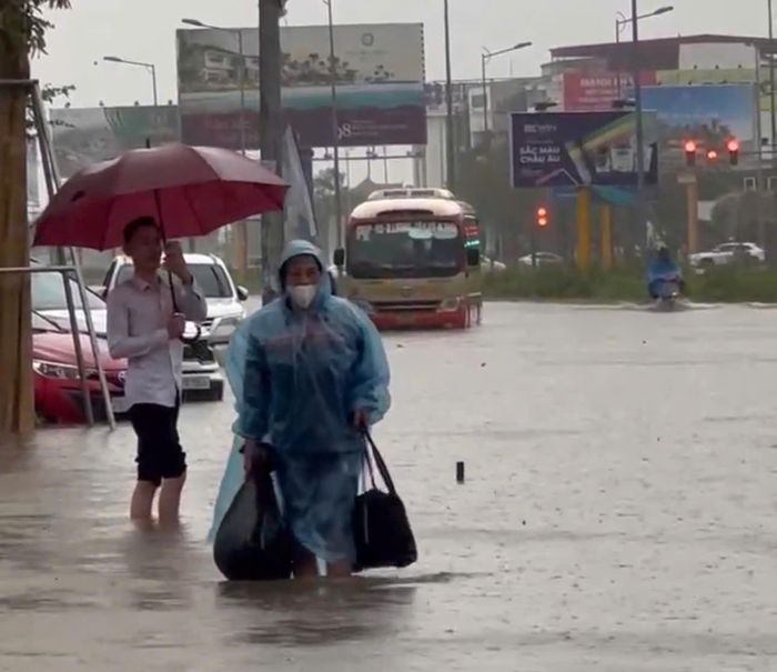 Hành khách phải lội nước sau khi xe buýt chết máy trên đại lộ Vinh - Cửa Lò. (Ảnh N.Dũng)