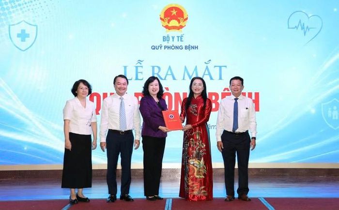 Uỷ viên Ban Chấp hành Trung ương Đảng, Bộ trưởng Bộ Y tế Đào Hồng Lan trao quyết định thành lập Quỹ Phòng bệnh cho Ban Giám đốc Quỹ. Ảnh: Trần Minh