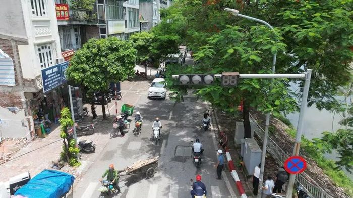 Dòng phương tiện trên tuyến đường lớn chạy sát khu vực những căn nhà đã được tháo dỡ. Việc mở rộng 381 Nguyễn Khang được kỳ vọng tạo thêm một hướng kết nối giao thông, giảm áp lực cho các tuyến đường lân cận.