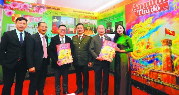 Đồng chí Lê Quốc Minh, Ủy viên Trung ương Đảng, Phó trưởng Ban Tuyên giáo và Dân vận Trung ương, Tổng Biên tập Báo Nhân Dân, Chủ tịch Hội Nhà báo Việt Nam (thứ ba từ trái sang) và các đại biểu tham quan, chụp ảnh lưu niệm tại gian trưng bày Báo An ninh Thủ đô tại Hội báo Xuân Giáp Thìn - Hà Nội 2024