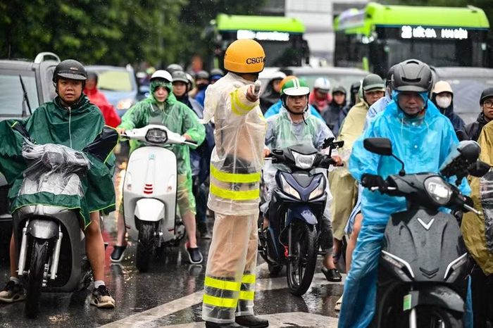 Dòng người áo mưa kín mít co cụm, ken đặc. Áp lực từ hàng trăm khối động cơ chực chờ tràn qua vạch kẻ đường, đòi hỏi người cảnh sát giao thông phải giữ cái đầu lạnh và nhịp còi dứt khoát.
