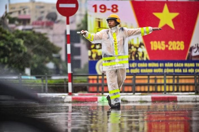 Nhịp bước vội vã vắt qua vạch kẻ đường, phía sau là tấm pano rực đỏ. Với những người lính làm nhiệm vụ trên mặt đường, mọi ngày bão giông hay lễ Tết đều có chung một nhịp điệu: không rời vị trí.