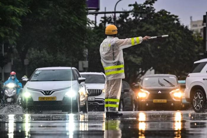 Hà Nội lên đèn. Ở tâm điểm của bức tranh ồn ào và vội vã ấy, họ vẫn đứng đó, chôn chân giữa mặt đường để vạn chuyến xe có thể lăn bánh nhanh hơn về nhà.