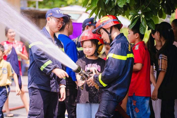 Học sinh TP.HCM được hướng dẫn sử dụng vòi rồng cứu hỏa. Ảnh: Công an TP.HCM.