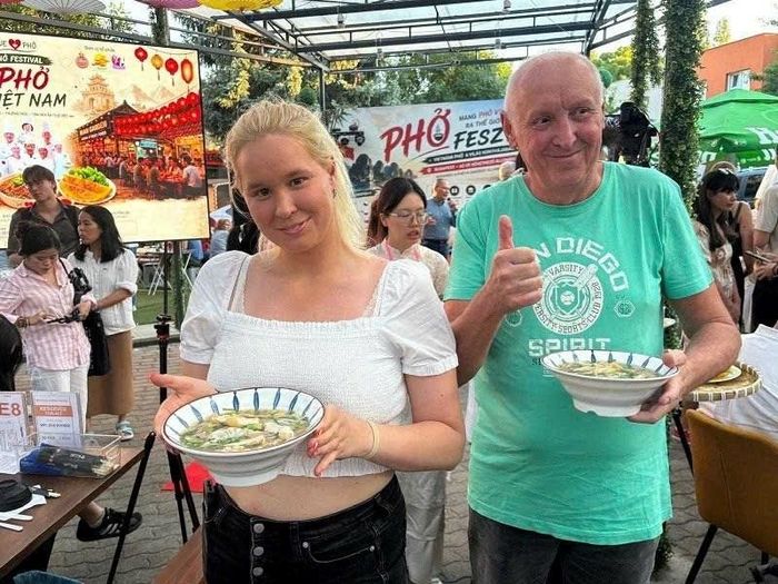 Khách nước ngoài thích thú khi được thưởng thức phở Việt Nam. Ảnh: TGCC