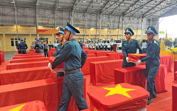 Các mẫu sinh phẩm hài cốt liệt sĩ được phủ vải đỏ in hình Quốc kỳ được vận chuyển cẩn trọng vào khu vực tổ chức lễ bàn giao