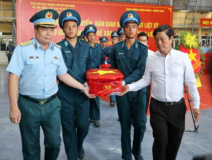 Trung tướng Vũ Hồng Sơn Tư lệnh Quân chủng Phòng không - Không quân và Chủ tịch Hội đồng nhân dân TP.HCM Võ Văn Minh thực hiện nghi thức bàn giao, sau đó đưa các mẫu sinh phẩm hài cốt liệt sĩ lên xe đưa tới Viện Hàn lâm Khoa học và Công nghệ Việt Nam để phục vụ phân tích, giám định ADN