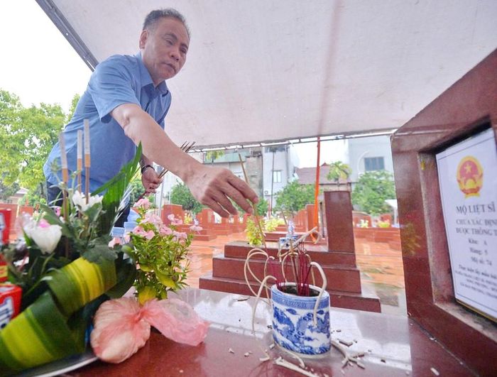 Ông Nguyễn Gia Hiển, Bí thư Đảng ủy, Chủ tịch HĐND xã Đan Phượng dâng hương tại mộ liệt sĩ chưa xác định danh tính trước khi tiến hành khai quật lấy mẫu ADN