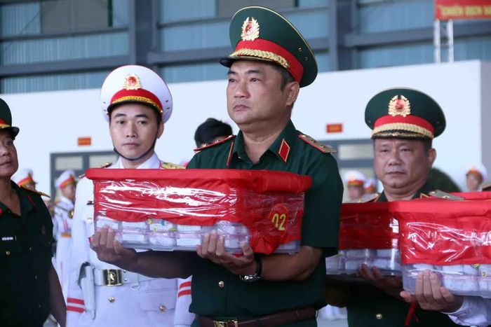 Trung tướng Lê Xuân Thế, Tư lệnh Quân khu 7 kính cẩn chuyển mẫu mẫu sinh phẩm hài cốt liệt sĩ lên máy bay vận chuyển ra Hà Nội để phục vụ công tác xét nghiệm ADN xác định danh tính liệt sĩ. Ảnh: Xuân Khu - TTXVN