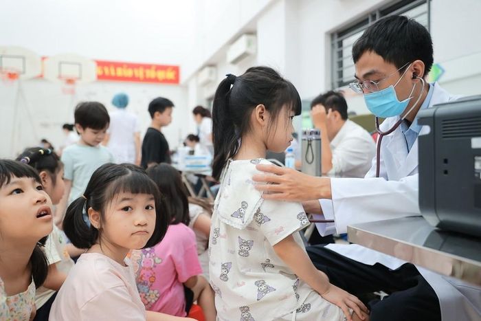Bác sĩ bệnh viện Xanh Pôn khám sức khoẻ cho học sinh trường tiểu học Ba Đình (phân hiệu 1). Ảnh: Minh Quyết - TTXVN