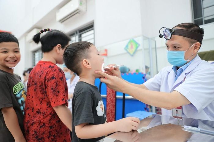 Bác sĩ bệnh viện Xanh Pôn khám sức khoẻ cho học sinh trường tiểu học Ba Đình (phân hiệu 1). Ảnh: Minh Quyết - TTXVN