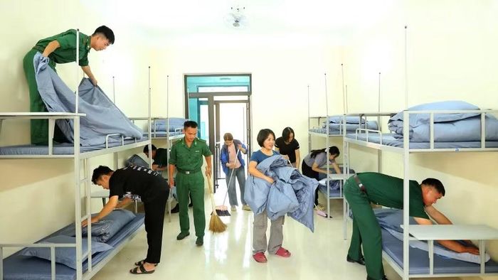 Cán bộ, chiến sĩ Đồn Biên phòng Chiềng On, Ban Chỉ huy Bộ đội Biên phòng tỉnh Sơn La phối hợp giáo viên chuẩn bị chỗ ngủ nghỉ cho các cháu học sinh nội trú. (Ảnh: QUÀNG HÙNG)