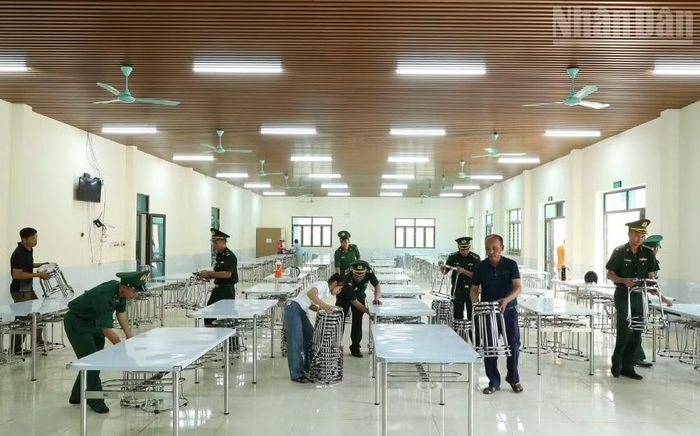 Cán bộ, chiến sĩ Đồn Biên phòng Chiềng On tổ chức sắp xếp bàn ghế và vệ sinh bếp ăn cho Trường phổ thông nội trú tiểu học và trung học cơ sở xã Yên Sơn. (Ảnh: QUÀNG HÙNG)