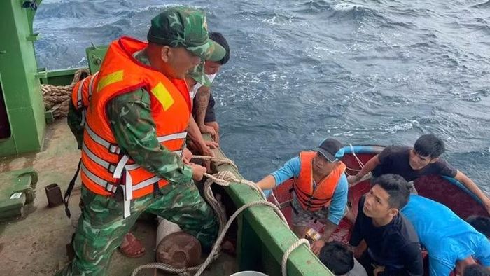 Cán bộ, chiến sĩ Đồn Biên phòng Cát Khánh đưa các ngư dân gặp nạn lên tàu an toàn. (Ảnh: CÔNG CƯỜNG)