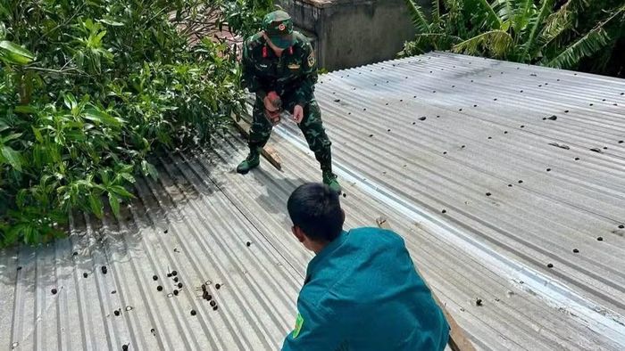 Lực lượng vũ trang xã Hòa Sơn giúp gia đình bà Nguyễn Thị Thu lợp lại mái nhà. (Ảnh: CTV)