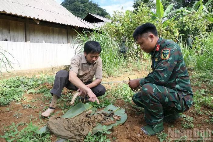 Ông Hầu Sào Chung và chiến sĩ Đội Tìm kiếm, quy tập hài cốt liệt sĩ bên các di vật được tìm thấy.