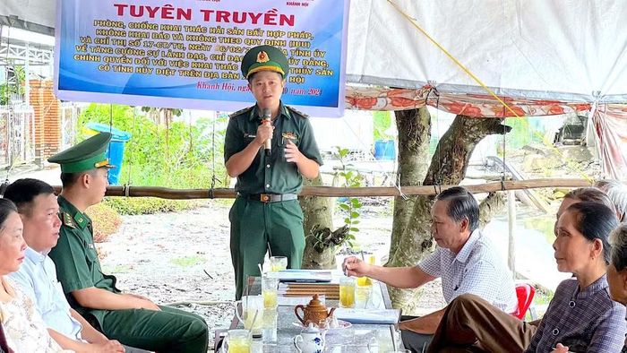 Thượng úy Nguyễn Trường Minh (đứng) tuyên truyền pháp luật về chống khai thác hải sản bất hợp pháp cho ngư dân vùng Đất Mũi, tỉnh Cà Mau. (Ảnh: ĐÌNH THẮNG)