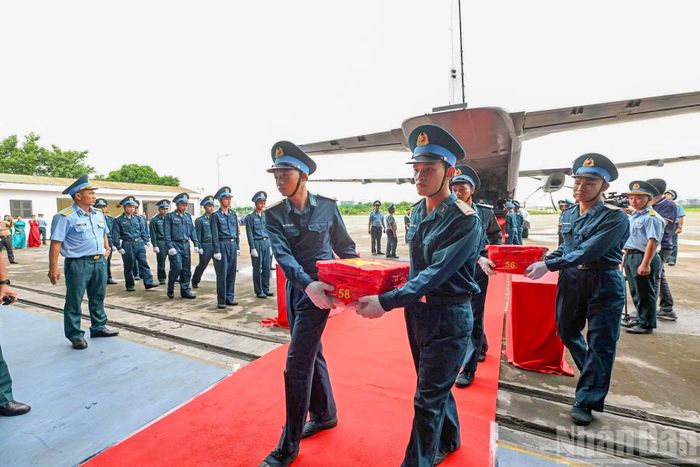 Nghi thức trang trọng chuyển mẫu hài cốt liệt sĩ từ máy bay xuống tại Sân bay Gia Lâm để làm lễ dâng hương tưởng niệm.