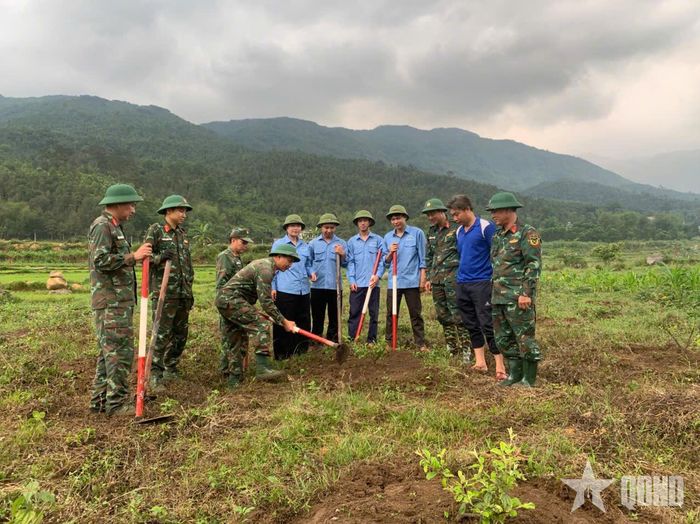 Cán bộ, nhân viên, trí thức trẻ tình nguyện Lâm trường 155, Đoàn Kinh tế - Quốc phòng 327 hướng dẫn người dân chăm sóc cây giống. Ảnh: ĐỨC PHÚC