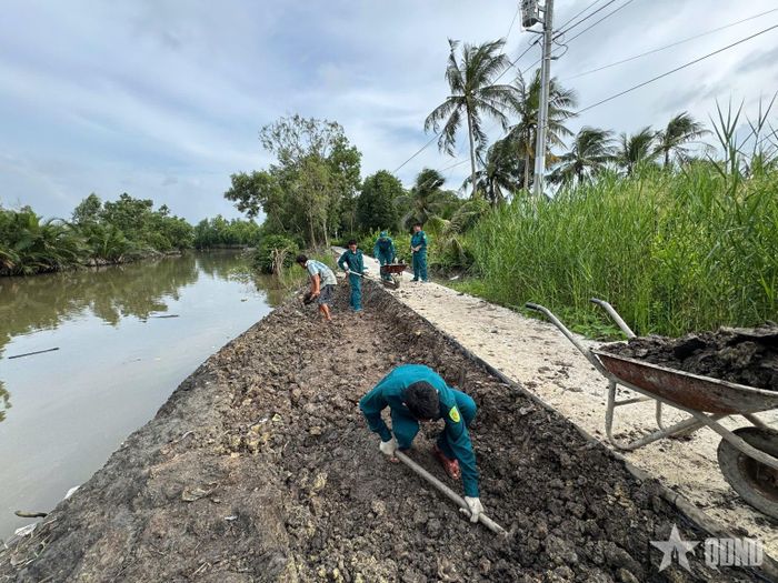 Cán bộ, chiến sĩ Ban CHQS xã Hưng Mỹ giúp bà Nguyễn Kim Riêng vận chuyển đất, tôn nền chuẩn bị xây dựng nhà mới.