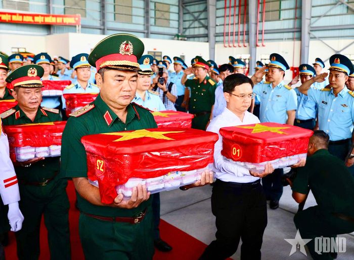 Trung tướng Lê Xuân Thế, Ủy viên Trung ương Đảng, Tư lệnh Quân khu 7; đồng chí Nguyễn Mạnh Cường và các đại biểu thực hiện nghi thức di chuyển các thùng đựng mẫu sinh phẩm hài cốt liệt sĩ ra máy bay.