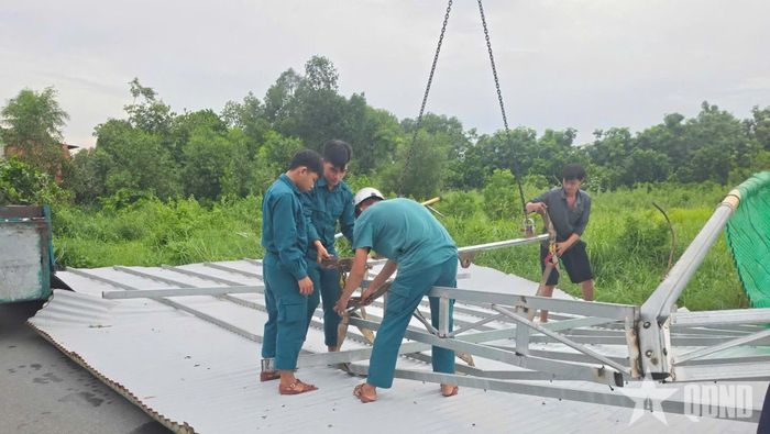 Dân quân hỗ trợ người dân khắc phục hậu quả dông lốc.