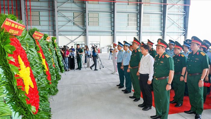 Các đại biểu dâng hoa, dâng hương tưởng niệm Anh hùng liệt sĩ trước khi máy bay cất cánh. Ảnh: MẠNH THẮNG