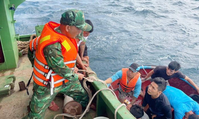  Lực lượng biên phòng dùng dây thừng để đưa các ngư dân bị nạn lên tàu cứu hộ 