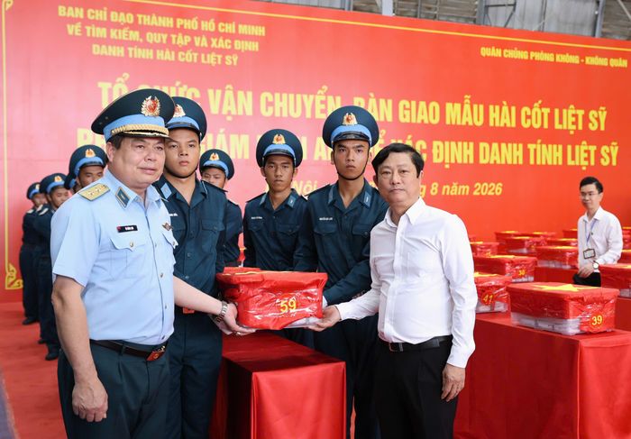 Chủ tịch HĐND TPHCM Võ Văn Minh và Trung tướng Vũ Hồng Sơn, Tư lệnh Quân chủng Phòng không - Không quân di chuyển mẫu sinh phẩm hài cốt liệt sĩ lên xe chuyên dụng tới Trung tâm giám định ADN, Viện Hàn lâm KH-CN Việt Nam. Ảnh: QUANG PHÚC