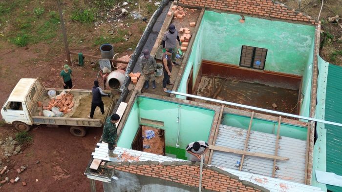  Lực lượng chức năng giúp dân sửa chữa nhà. Ảnh: HỮU PHÚC 