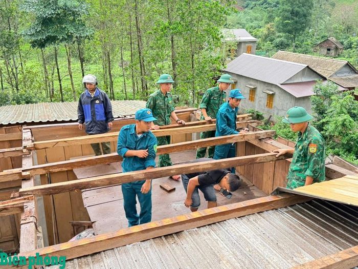 Lực lượng vũ trang phối hợp gia cố và lợp lại mái nhà cho 4 hộ dân bị thiệt hại. Ảnh: Hoài Nam