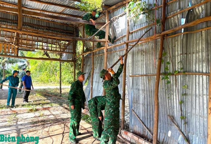 Cán bộ, chiến sĩ Đồn Biên phòng Khánh Hội tháo dỡ ngôi nhà đã xuống cấp và bị sập của bà Lê Kiều Diễm. Ảnh: Hoàng Tá