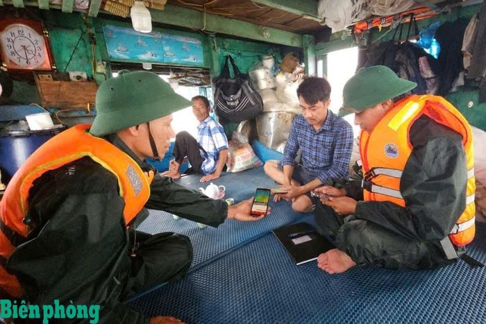 Cán bộ Bộ đội Biên phòng thành phố Hải Phòng thông tin về ấp thấp nhiệt đới cho bà con ngư dân. Ảnh: Nguyễn Khánh