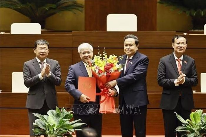 Chủ tịch Quốc hội Trần Thanh Mẫn trao Nghị quyết và tặng hoa chúc mừng đồng chí Đỗ Văn Chiến. ﻿Ảnh: Doãn Tấn/TTXVN 