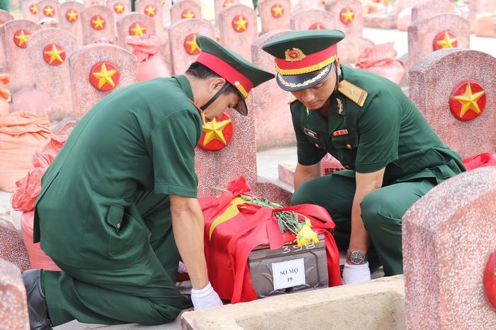Nghi thức hạ kiệu để an táng các hài cốt liệt sĩ tại Nghĩa trang liệt sĩ Nghi Lộc (Ảnh: Thiên Ý).