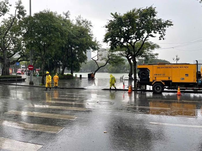Lực lượng công nhân và phương tiện chuyên dụng túc trực tại các điểm trọng yếu trên địa bàn Hà Nội để khơi thông dòng chảy, sẵn sàng xử lý các tình huống ngập úng.