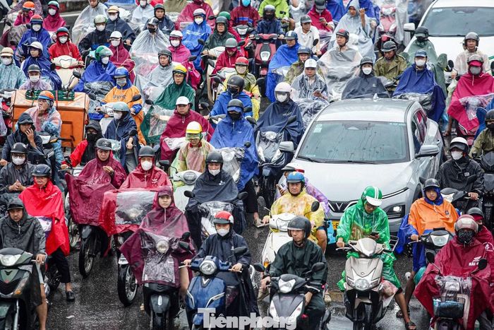 Người dân chật vật đi học, đi làm giữa dòng phương tiện ùn ứ kéo dài dưới cơn mưa tầm tã.