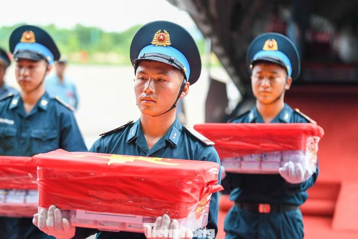 Chiến sĩ di chuyển các hộp đựng mẫu sinh phẩm hài cốt liệt sĩ từ máy bay. (Ảnh: Dương Triều)
