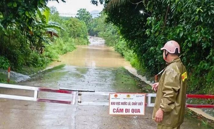 Điểm tràn ở xã Hóa Quỳ nước dâng cao, lực lượng chức năng đã lắp đặt gác chắn cảnh báo.
