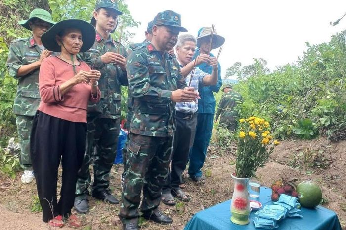 Bà Chương cùng bộ đội thắp hương chuẩn bị khai quật mộ liệt sĩ. Ảnh: Đội K51