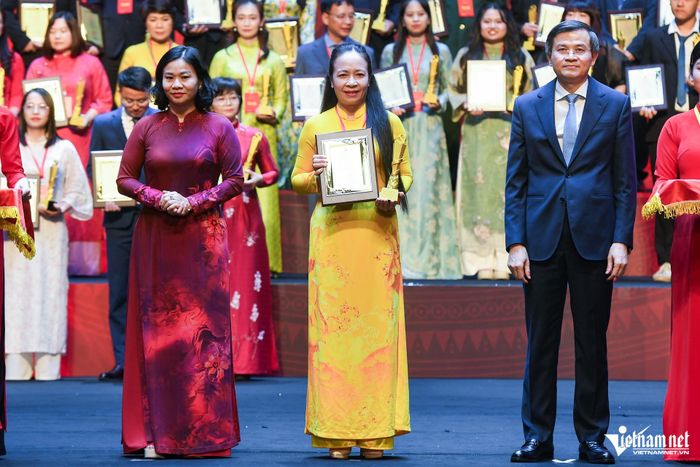 Ông Đoàn Minh Huấn, Ủy viên Bộ Chính trị, Giám đốc Học viện Chính trị quốc gia Hồ Chí Minh và bà Nguyễn Thị Tuyến, Ủy viên Trung ương Đảng, Phó Bí thư Đảng ủy Chính phủ trao giải A cho tác giả Trịnh Thị Hoa. Ảnh: Thạch Thảo