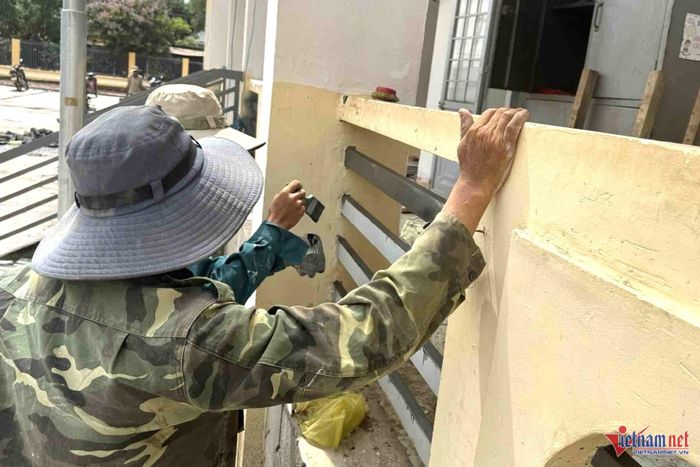 Công nhân đang sơn lan can phòng học. Ảnh: Hải Dương