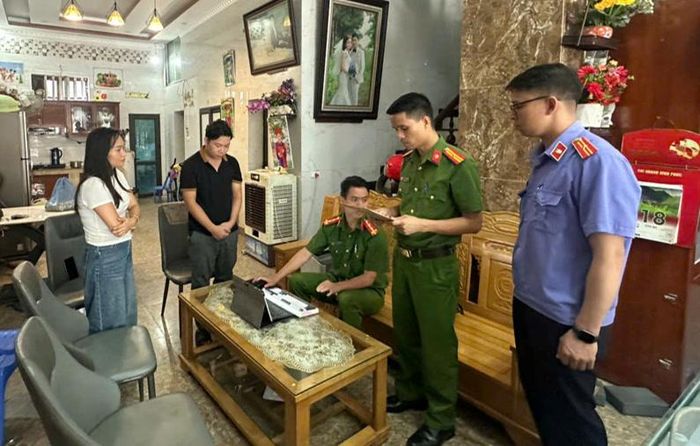 Kiểm sát viên kiểm sát việc thi hành Lệnh khám xét nơi ở của Nguyễn Anh Bình (áo đen).