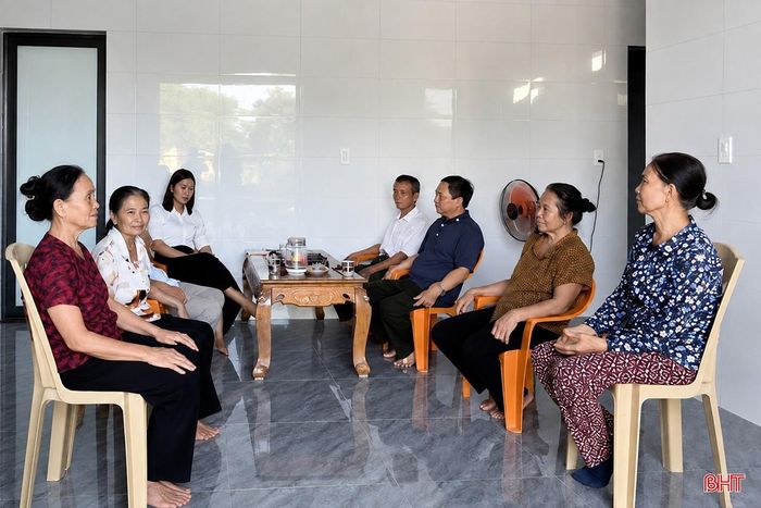 Bà Trần Thị Lý (ngoài cùng bên trái) trò chuyện cùng bà con láng giềng trong ngôi nhà mới.