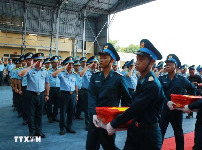 Nghi thức trang trọng chuyển mẫu hài cốt liệt sỹ từ máy bay xuống tại Sân bay Gia Lâm để làm lễ dâng hương tưởng niệm. (Ảnh: Trọng Đức/TTXVN)