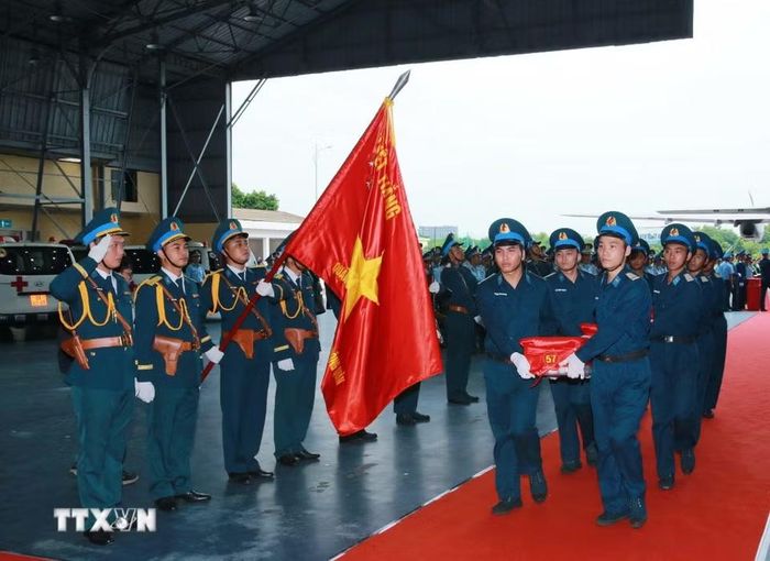 Nghi thức trang trọng chuyển mẫu hài cốt liệt sỹ từ máy bay xuống tại Sân bay Gia Lâm để làm lễ dâng hương tưởng niệm. (Ảnh: Trọng Đức/TTXVN)