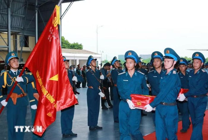 Nghi thức trang trọng chuyển mẫu hài cốt liệt sỹ từ máy bay xuống tại Sân bay Gia Lâm để làm lễ dâng hương tưởng niệm. (Ảnh: Trọng Đức/ TTXVN)