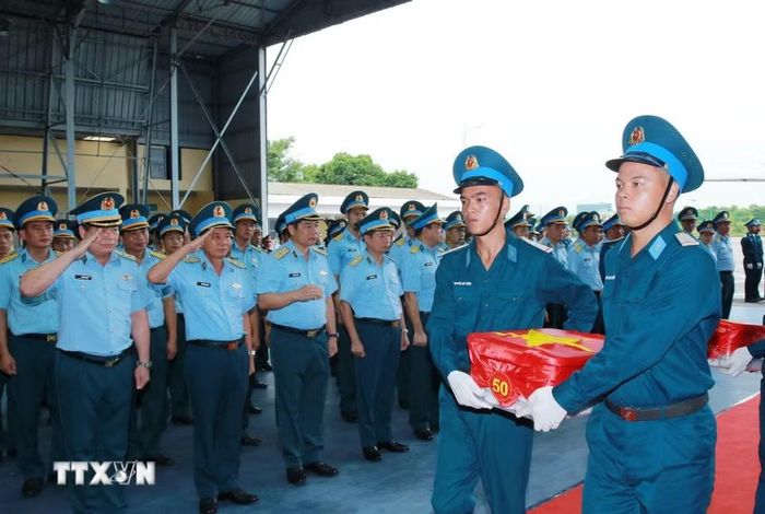 Nghi thức trang trọng chuyển mẫu hài cốt liệt sỹ từ máy bay xuống tại Sân bay Gia Lâm để làm lễ dâng hương tưởng niệm. (Ảnh: Trọng Đức/TTXVN)