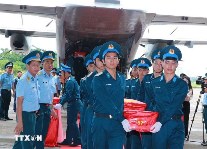 Nghi thức trang trọng chuyển mẫu hài cốt liệt sỹ từ máy bay xuống tại Sân bay Gia Lâm để làm lễ dâng hương tưởng niệm. (Ảnh: Trọng Đức/TTXVN)